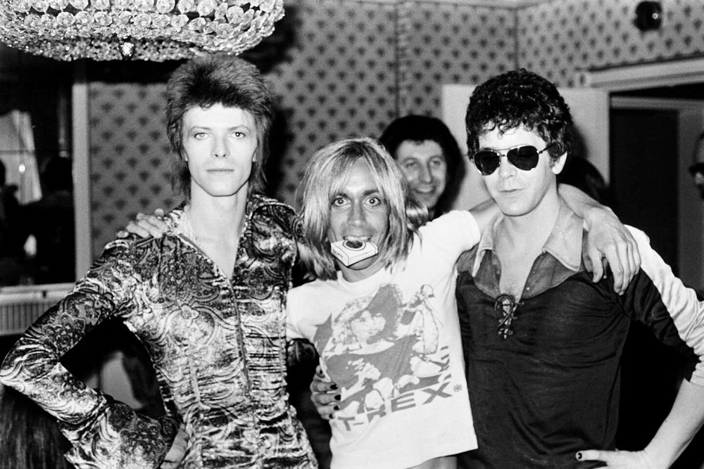 David Bowie, Iggy Pop and Lou Reed posing in the early seventies. Bowie poised and posed and preening in an androgynous glam outfit, Lou Reed the same but less enthusiastic, Iggy wearing aT-Rex t-shirt with a pack of smokes in his mouth and loving the moment.