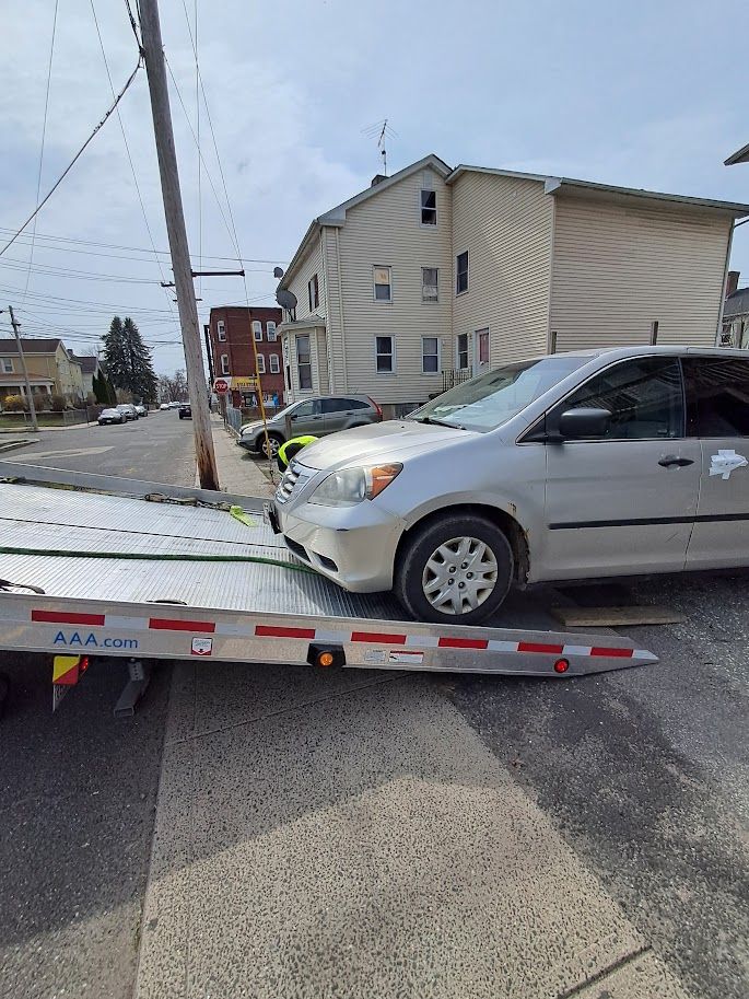 Van being loaded on flay bed tow truck