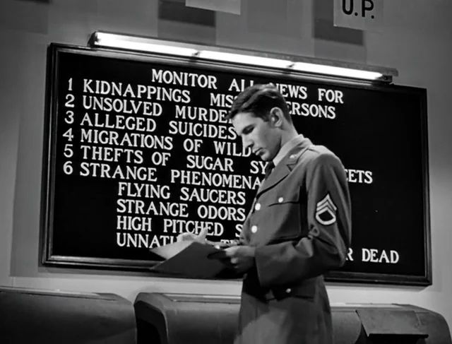 20-something Nimoy in a Sargent uniform standing before a board listing strange news reports to be monitored:
Kidnappings
Unsolved murders
Alleged suicides
Strange migrations
Thefts of sugary sweets
Strange phenomenon 

It’s in black and white 