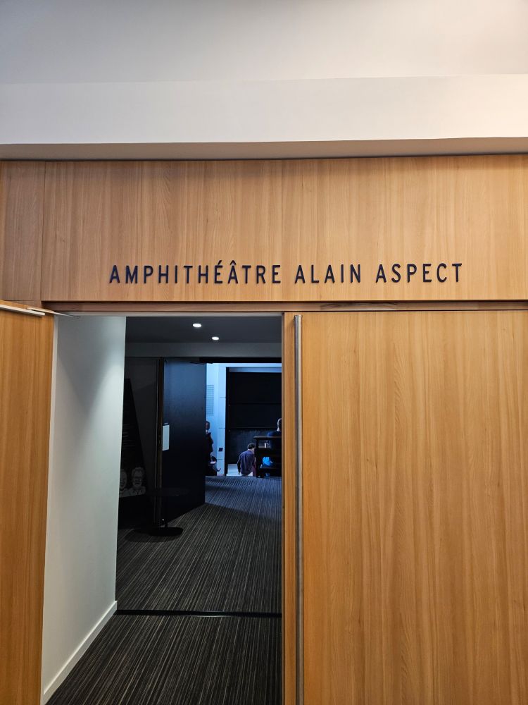 Wooden door at the entrance of a lecture hall. The text above reads "Amphithéâtre Alain Aspect"