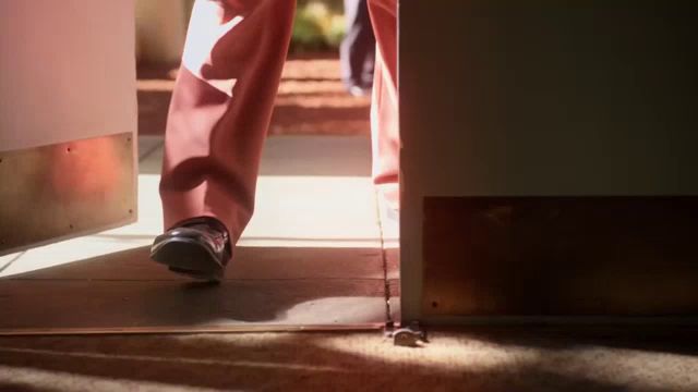 a person 's feet are shown walking through a doorway