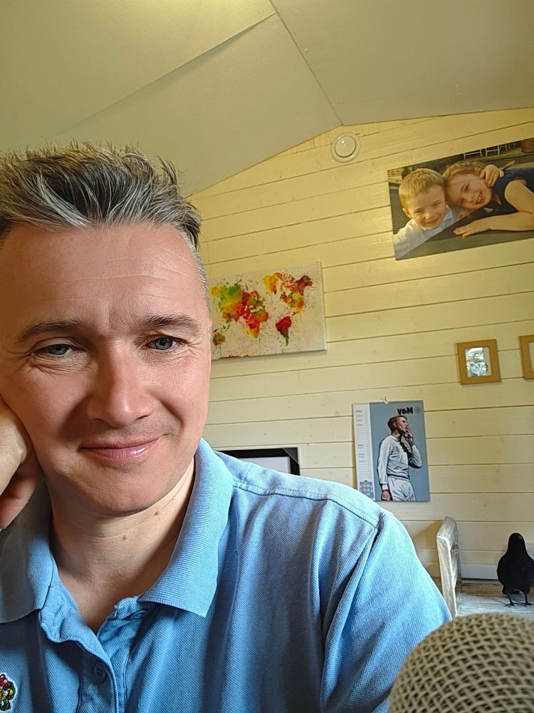 Man in an office with an image of Jack Charlton behind him. 