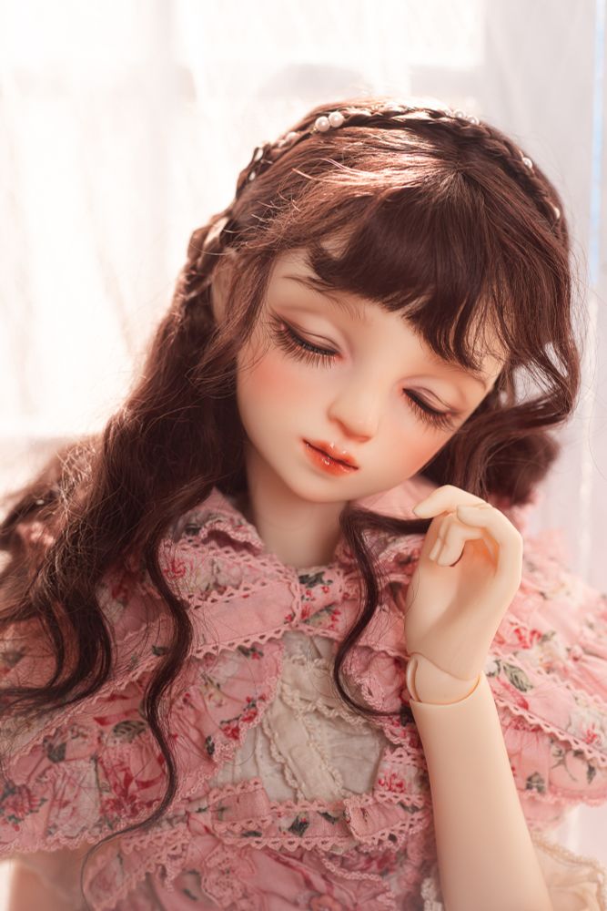 Volks Sweet Dream Tae with long, wavy, brown wig and dressed in Pink House posing in front of a brightly lit window