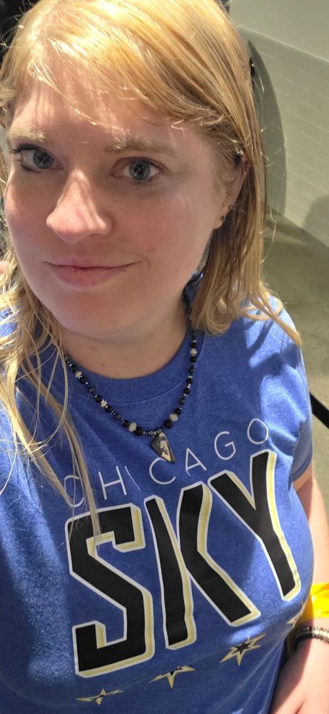 White blonde woman in a blue Chicago sky shirt