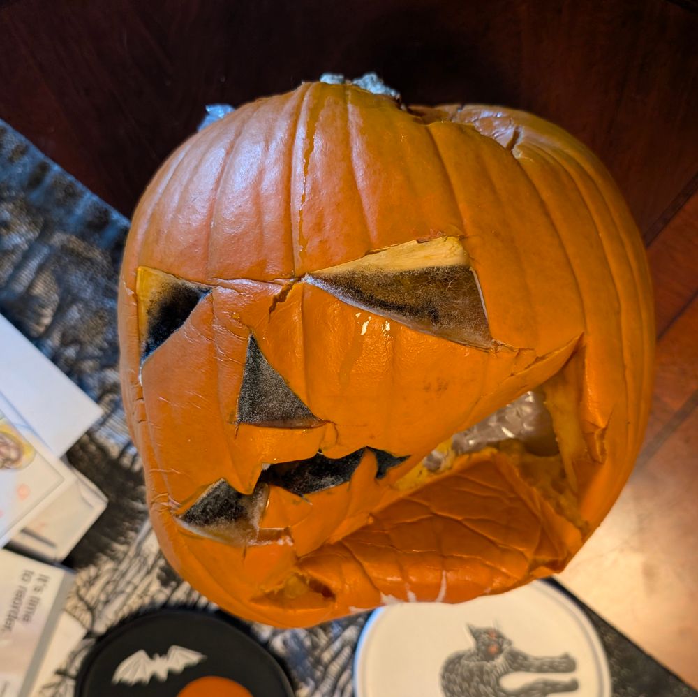 a collapsed carved pumpkin full of mold