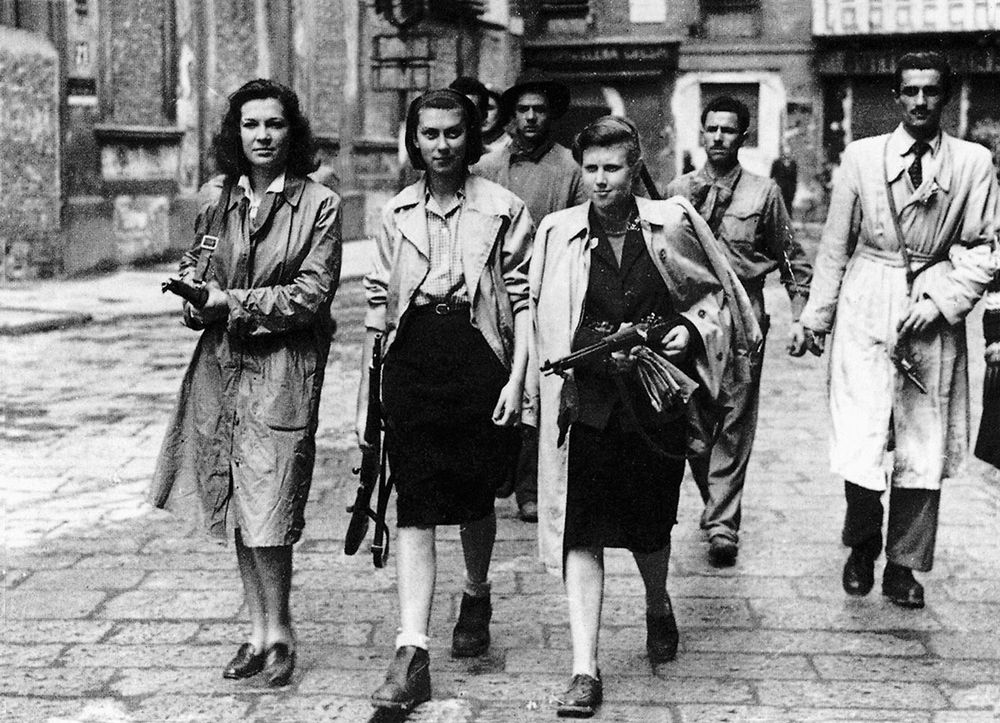 partigiane in trench coats carrying rifles in the streets of Milan in 1945