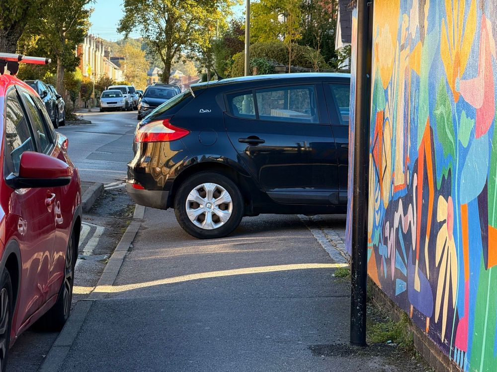 A black car parking across the pavement in Howard St, Oxford 