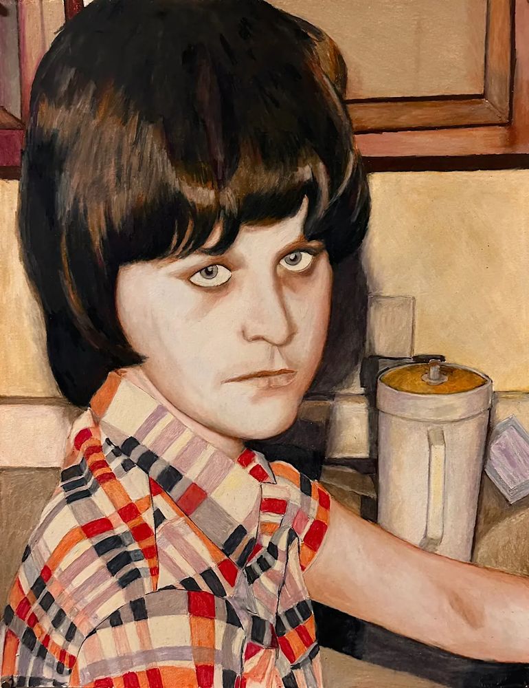 Alt text: portrait of a young woman standing by the sink, staring out at the viewer, a serious almost mad look. She’s wearing a red and black plaid shirt.
