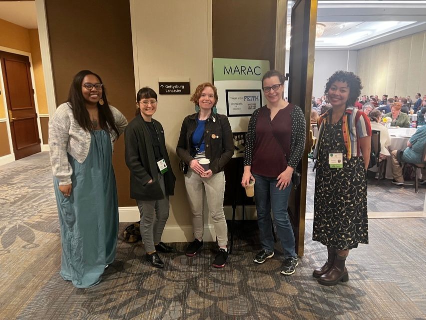 five people standing in front of a MARAC sign