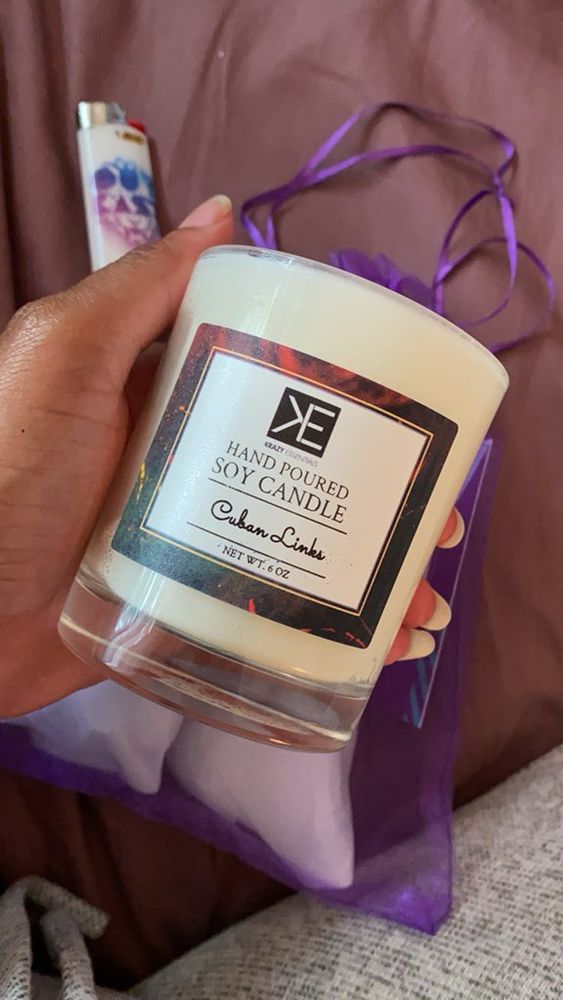 Pic of hand holding Krazy essentials’ Cuban links candle 