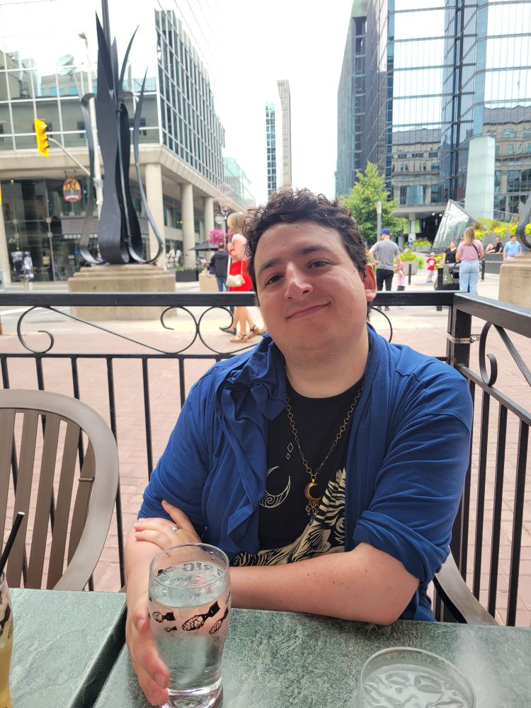 My beautiful boyfriend being cute at lunch in their Blue sweater/robe thing and gold necklace. 
Just look at them. My god, so cute 🥰