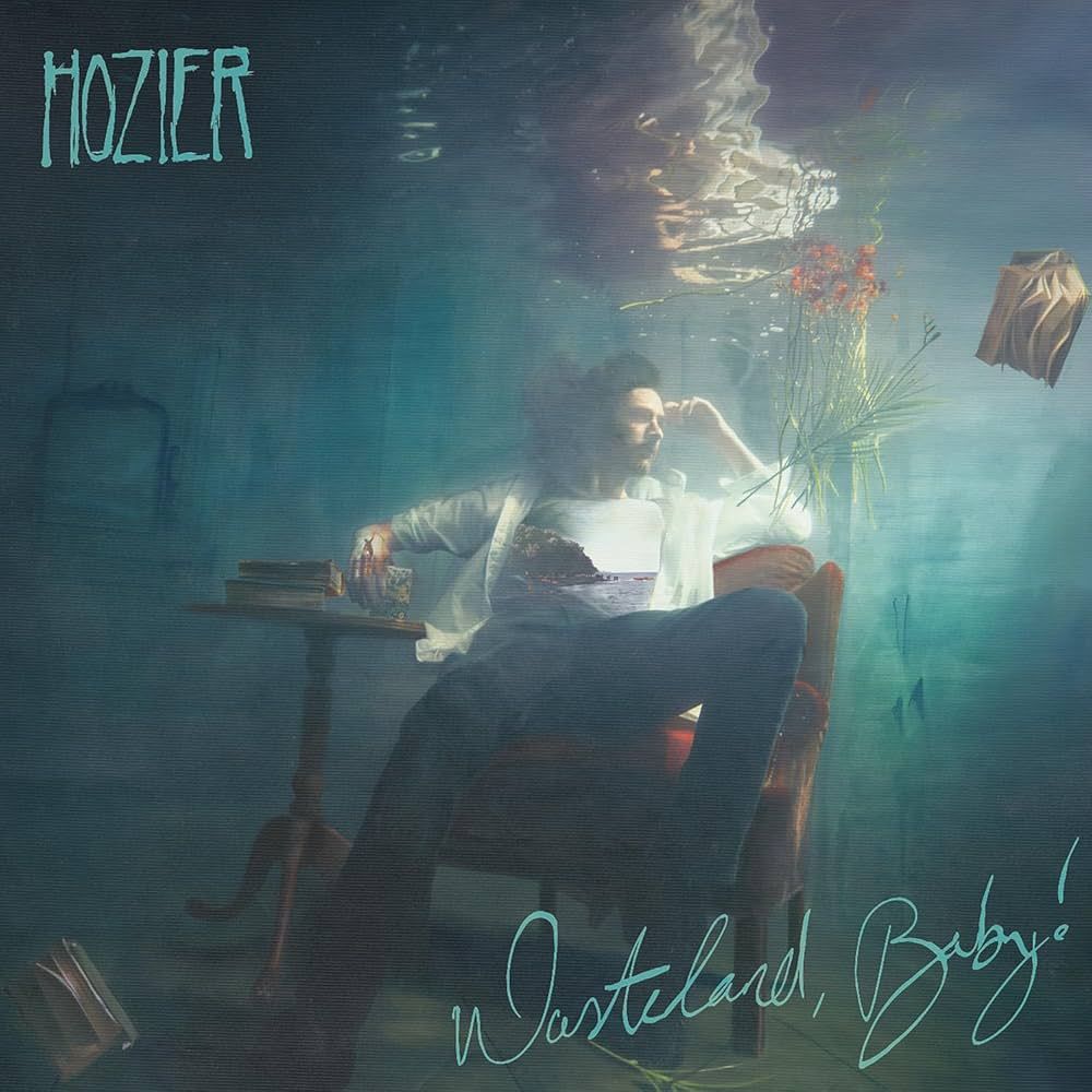The album cover for Hozier's "Wasteland, Baby!" showing him sitting sprawled across a velvet chair in a romantic underwater tableau.