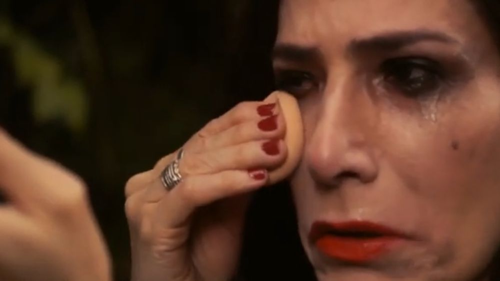 A personagem Inaura, de Lisbela e o Prisioneiro, com uma esponja em seu rosto, retocando a maquiagem borrada após chorar