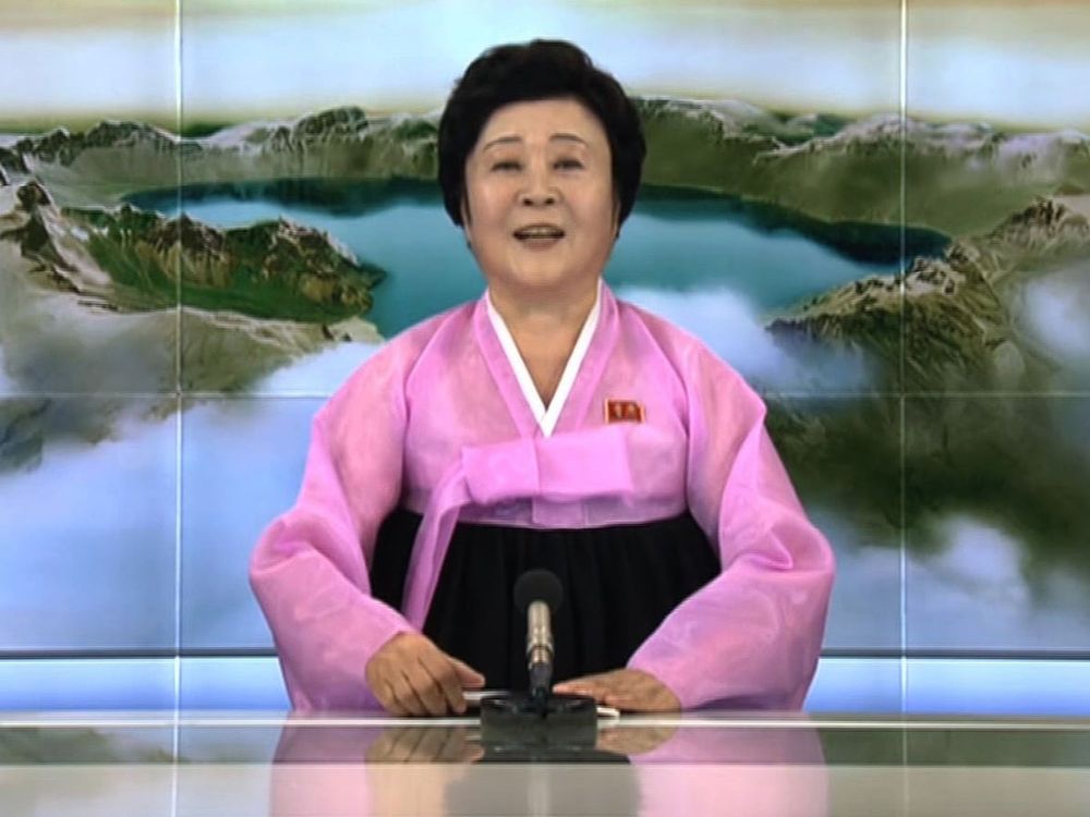 A photo of a North Korean newsreader wearing a pink kimono. 