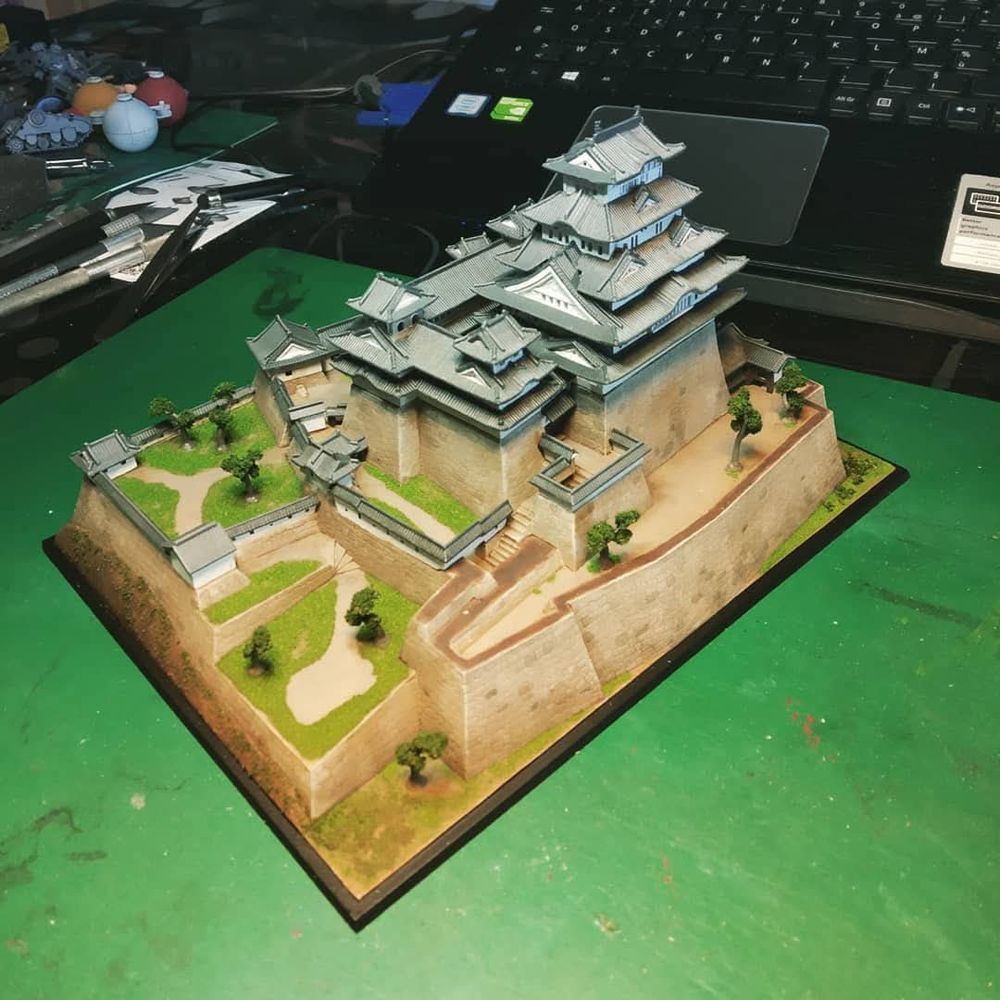 Photo d'une maquette de châteaux japonais avec ses murs d'enceinte, cours et toitures caractéristiques.