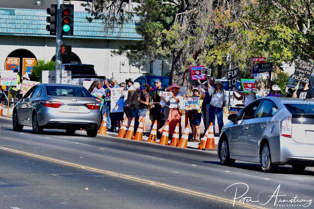 People on the sidewalk with political signs 