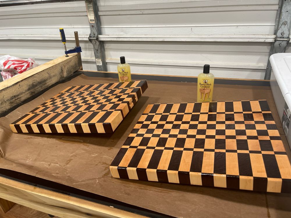Two butcher blocks elevated on one side each to allow mineral oil to weep from them. 