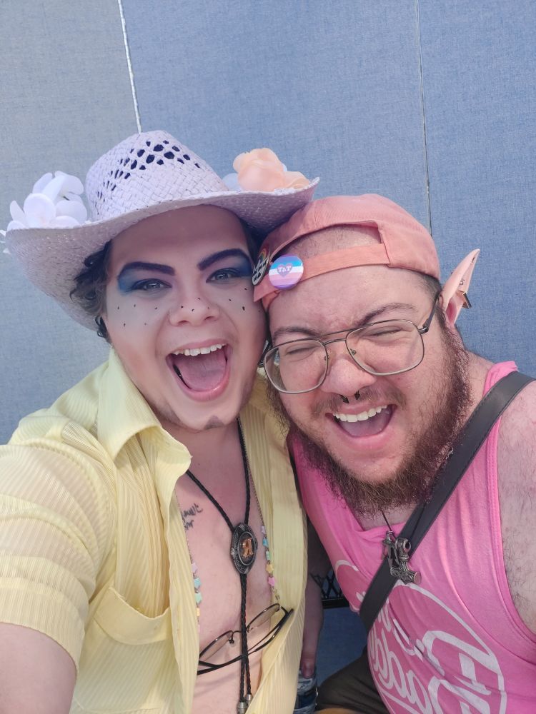 A selfie of Richard Rider, a cowboy-inspired drag king, next to his boyfriend Jason Larock, both giving big smiles