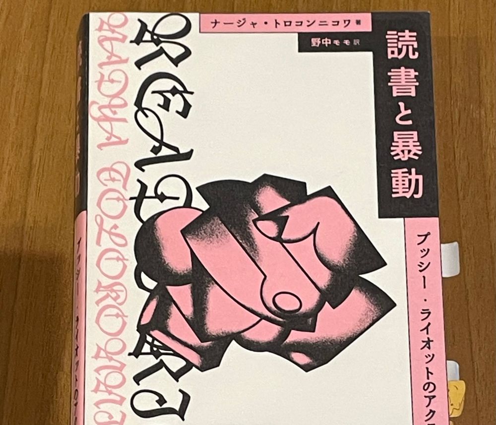 ナージャ・トロコンニコワ著作の『読書と暴動　プッシー・ライオットのアクティビズム入門』の表紙の写真です。
黒色とピンク色で構成されたロゴと、キュビスム表現で握り拳が描かれています。