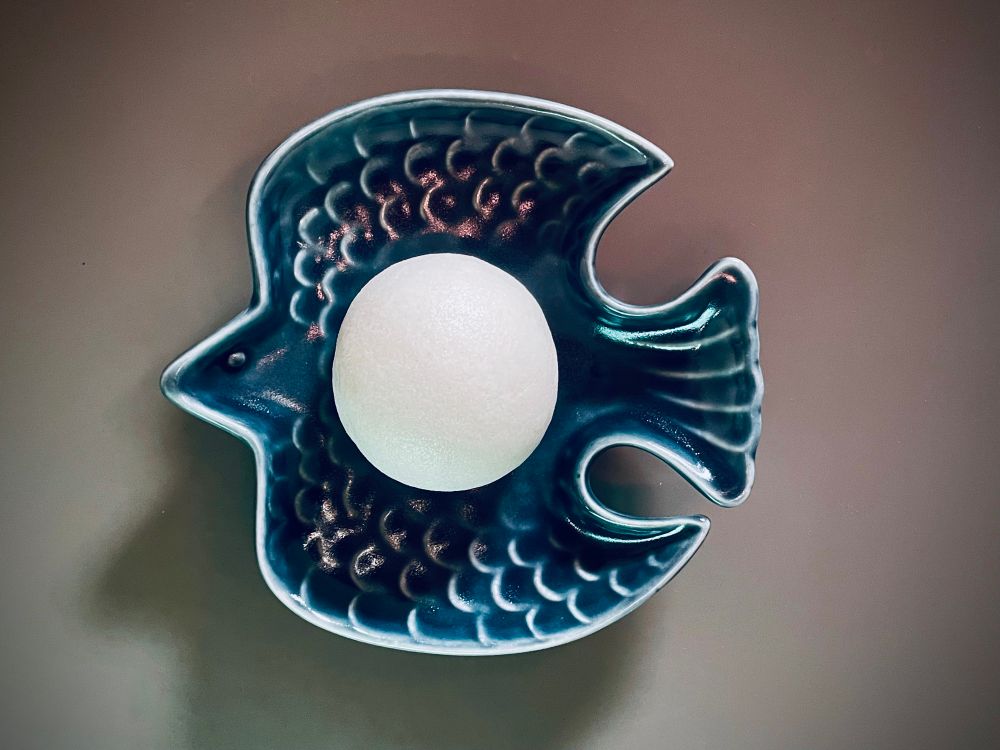 薯蕷饅頭(じょうようまんじゅう)の写真です。
藍色の翼を広げた小鳥の形の皿の上に、白くてまん丸なまんじゅうがひとつ乗っています。