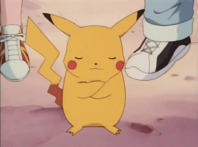 a pikachu with its eyes closed is standing next to a person 's foot