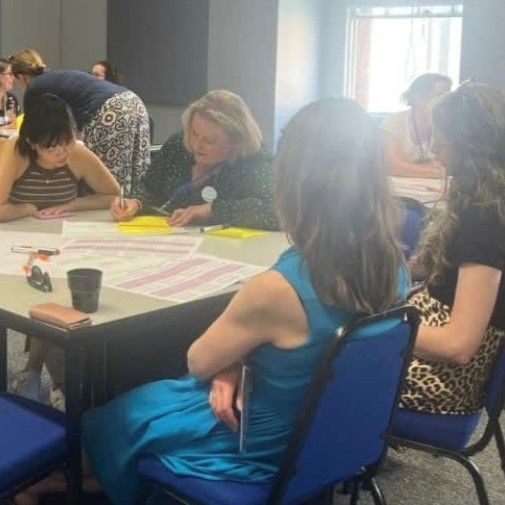 Staff at AldCon25 working together around a table