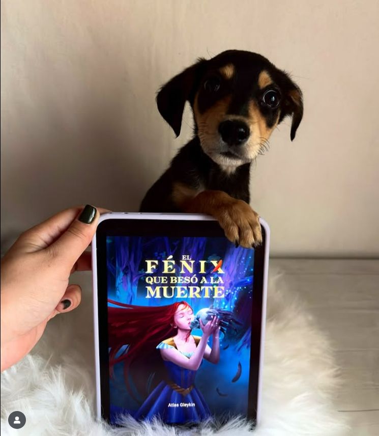 Imagen de un cachorro precioso aguantando un e-reader con la patita. El e-reader muestra la portada de mi novela.