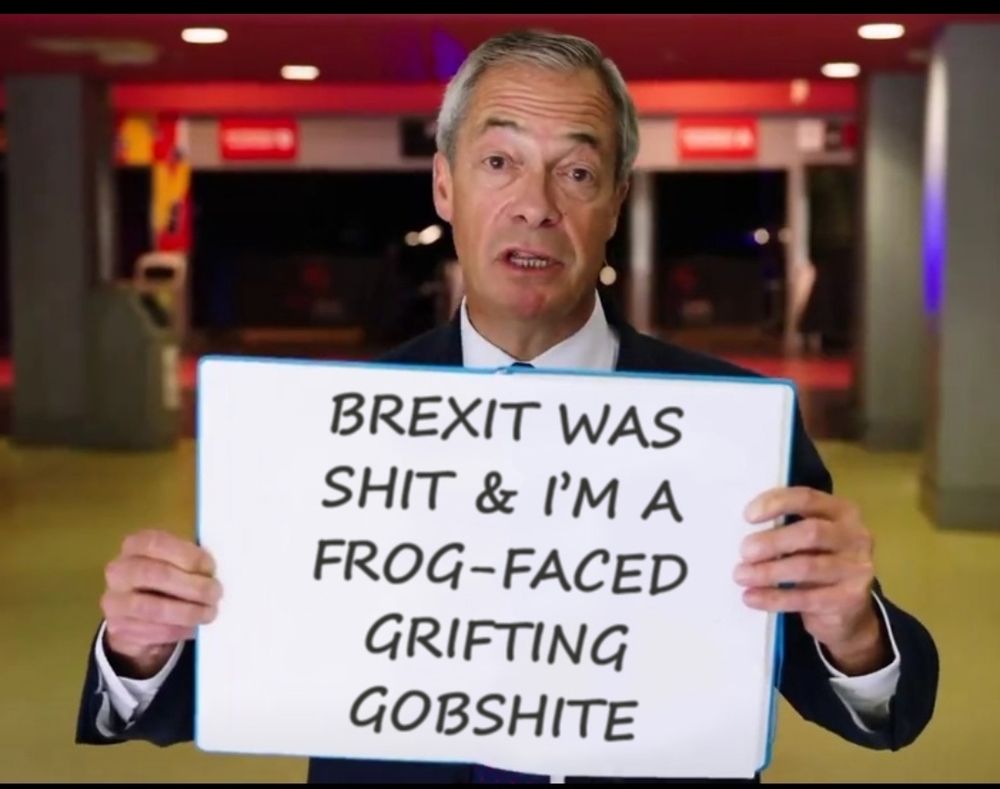 Nigel farage holding a sign that says 'Brexit was shit and I'm a frog faced grifting gobshite'
