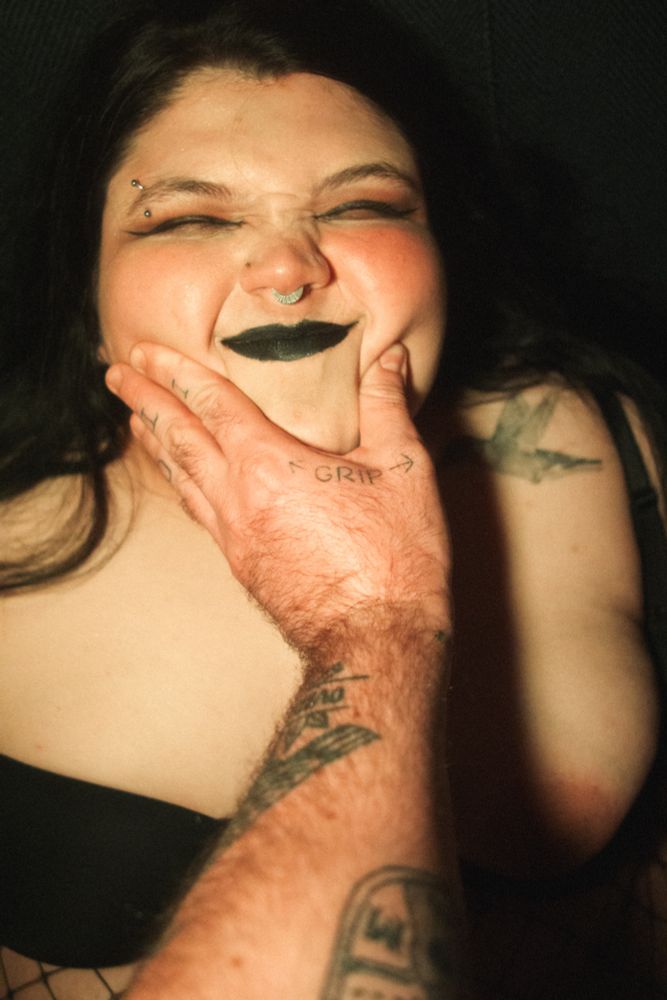 Raven makes a scrunchy face while a hand pinches her cheeks 