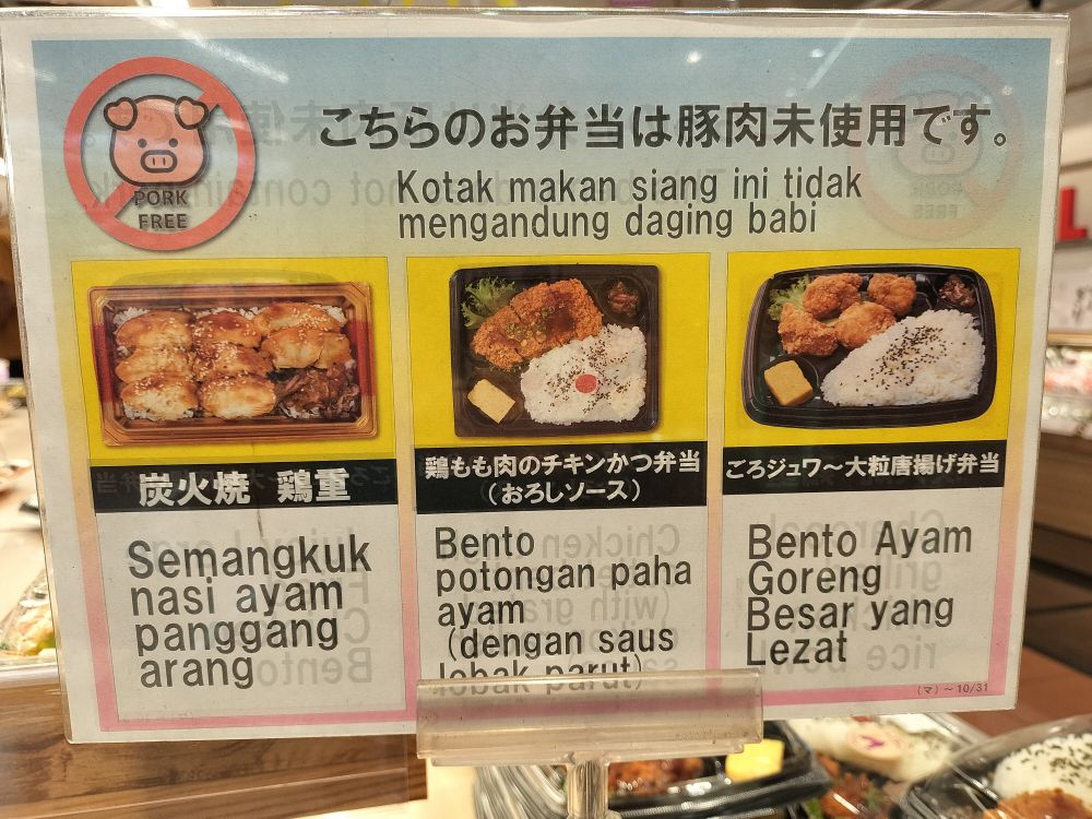 スーパーのお弁当売り場の写真。いくつかの鶏肉を使った弁当について、写真・何弁当かの説明と共に「豚肉未使用です」と書かれたポスターが掲示されている。