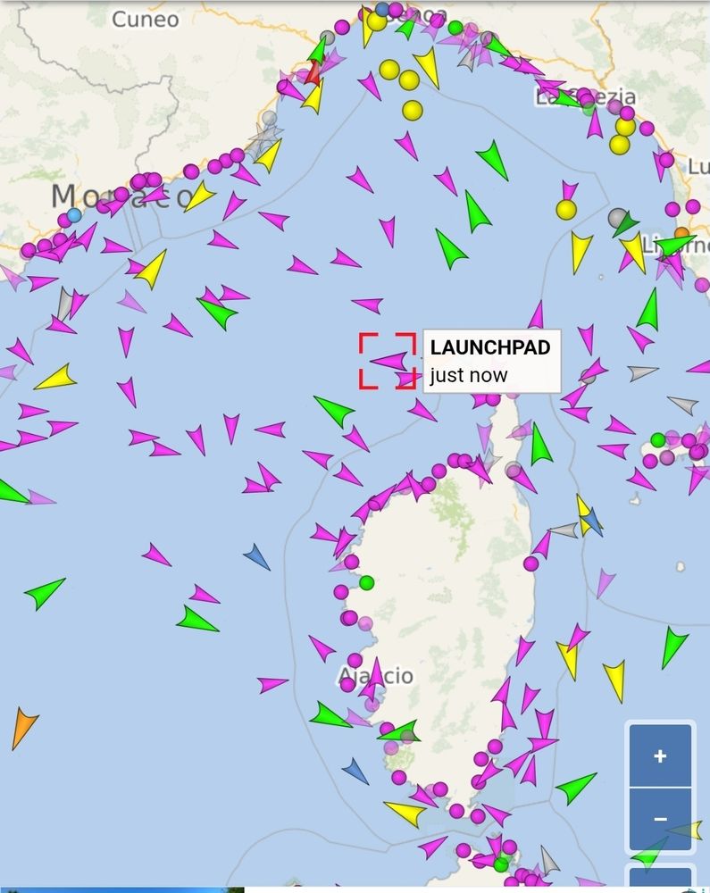 Schiffsverkehrskarte des Ligurischen Meers und des nördlichen Tyrrhenischen Meers zwischen der französischen Riviera, Italien und der Insel Korsika. Bunte Pfeile markieren die Fahrtrichtungen verschiedener Schiffe, wobei Farben vermutlich unterschiedliche Schiffstypen anzeigen. In der Mitte ist das Schiff „LAUNCHPAD“ mit einem roten Rahmen und der Markierung „just now“ hervorgehoben. Die Karte zeigt Städte wie Monaco, La Spezia, Livorno und Ajaccio.