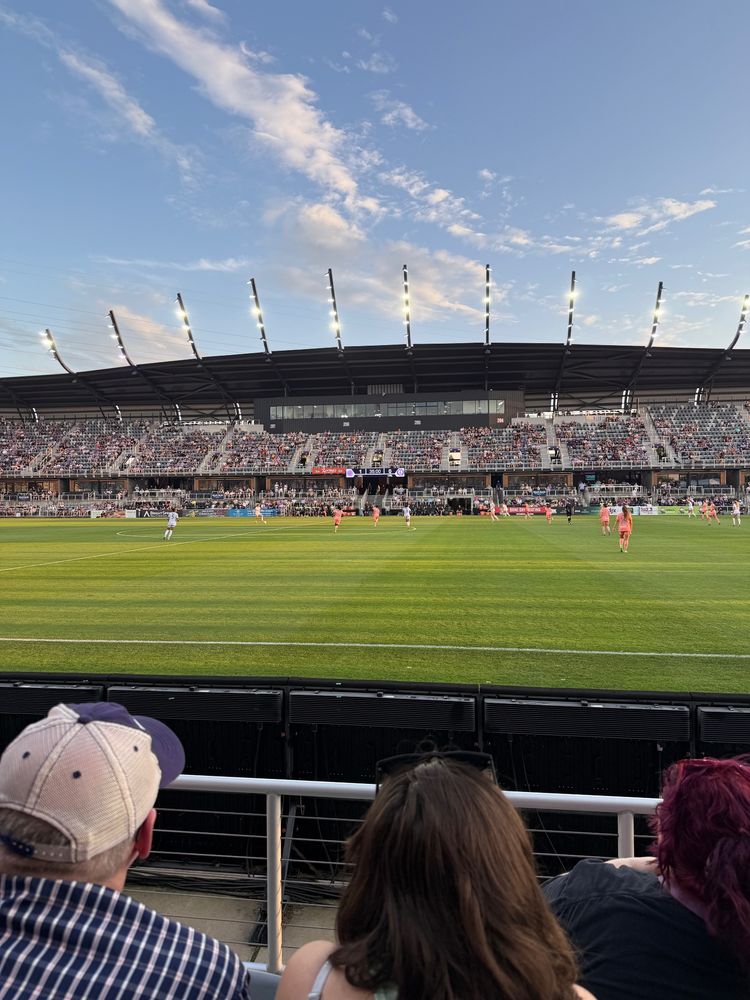 A football pitch, from just right of midfield, with women players in a game. 