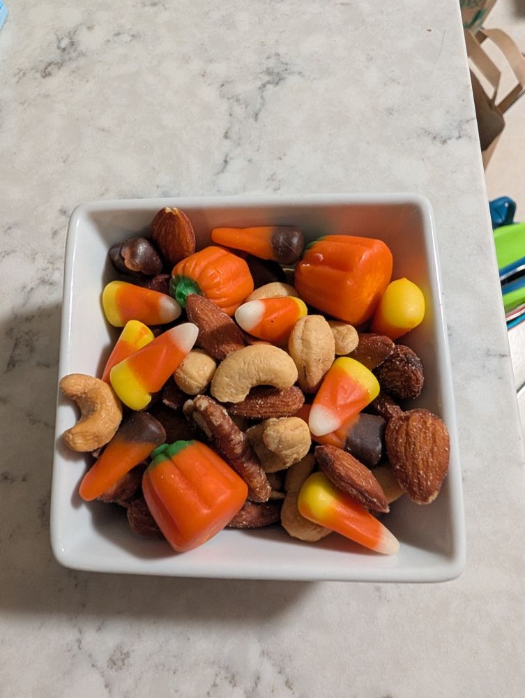 candy corn, mallowcreme pumpkins, and mixed nuts in a dish