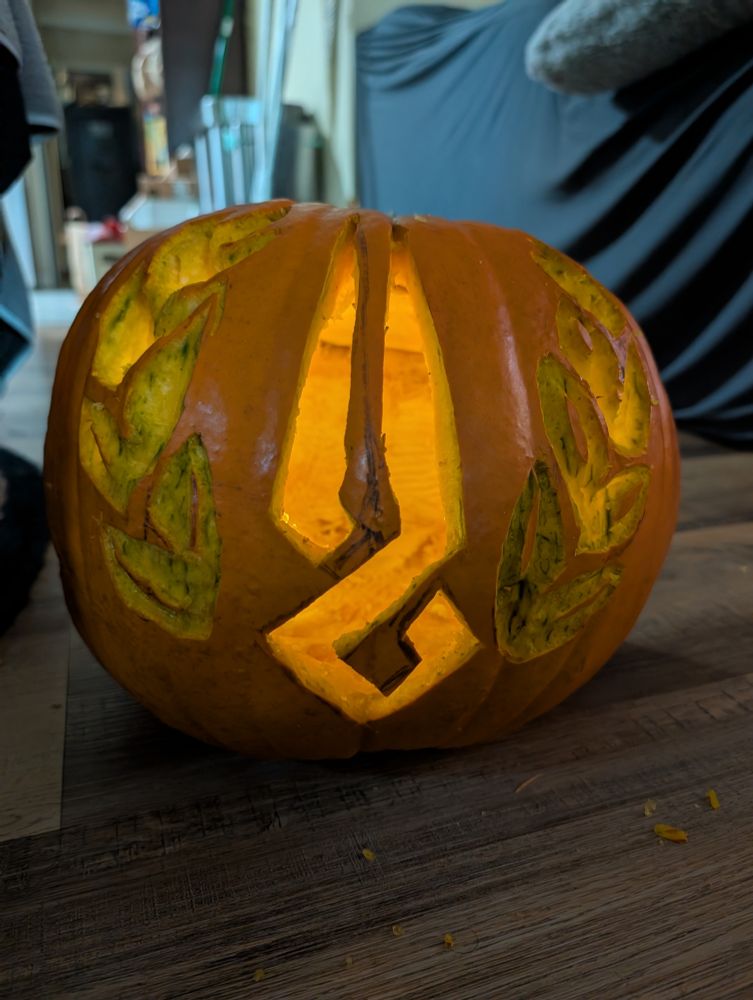 lit pumpkin carved to resemble the Hades symbol and laurels from Hades/Hades II
