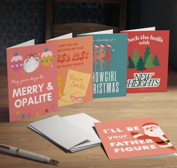 Taylor Swift Life of a showgirl inspired Christmas cards from Etsy. "May your days be merry & opalite". "Hope you get everything on your wishlist this holiday season", "I'm dreaming of a showgirl Christmas", "Deck the halls with new heights of manhood" and "I'll be your father figure".