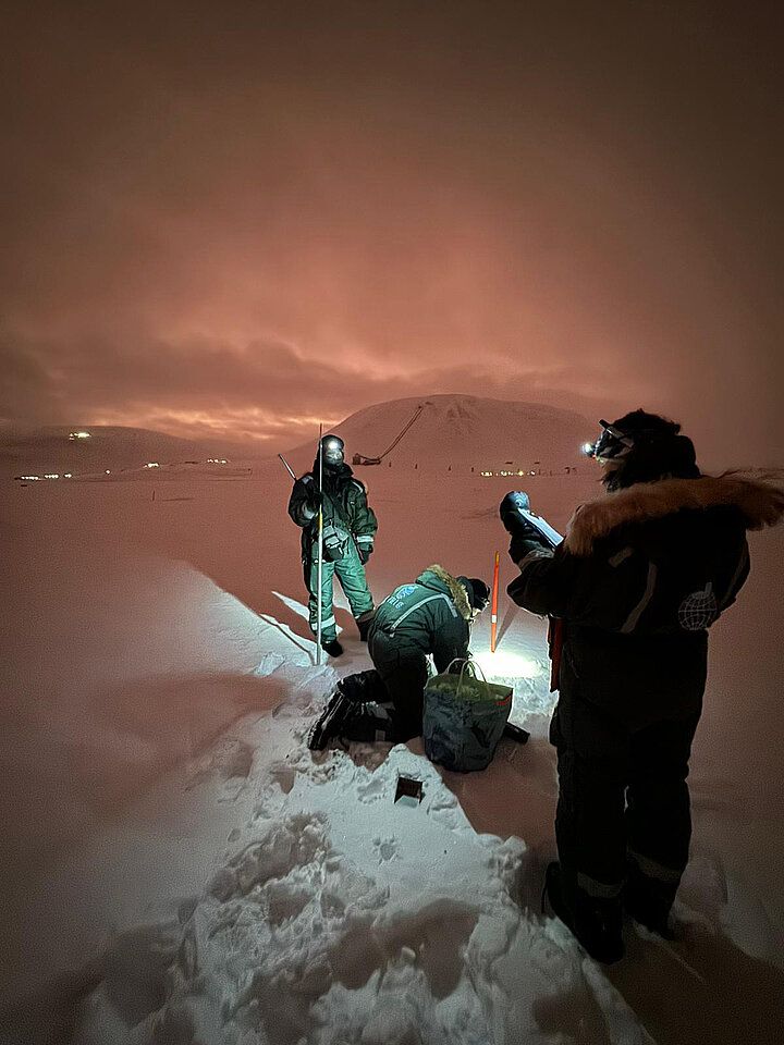 Researchers and students taking in-situ measurements in the snow on Svalbard.