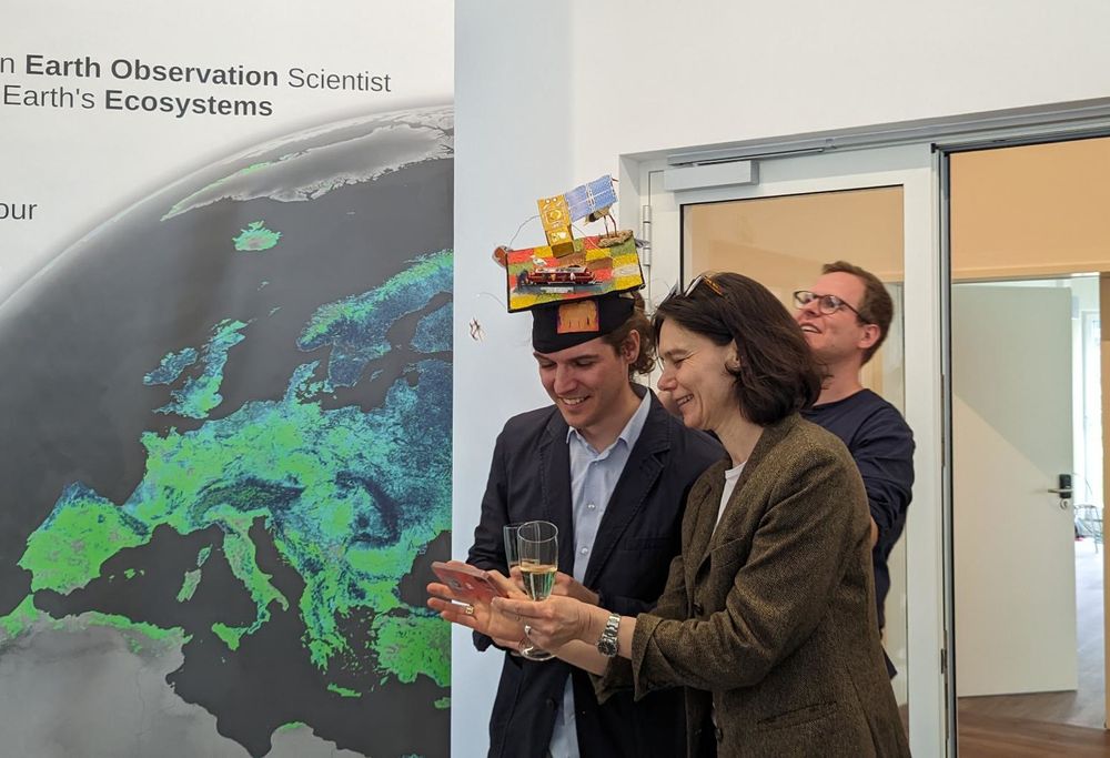 Two persons, one with a PhD hat.