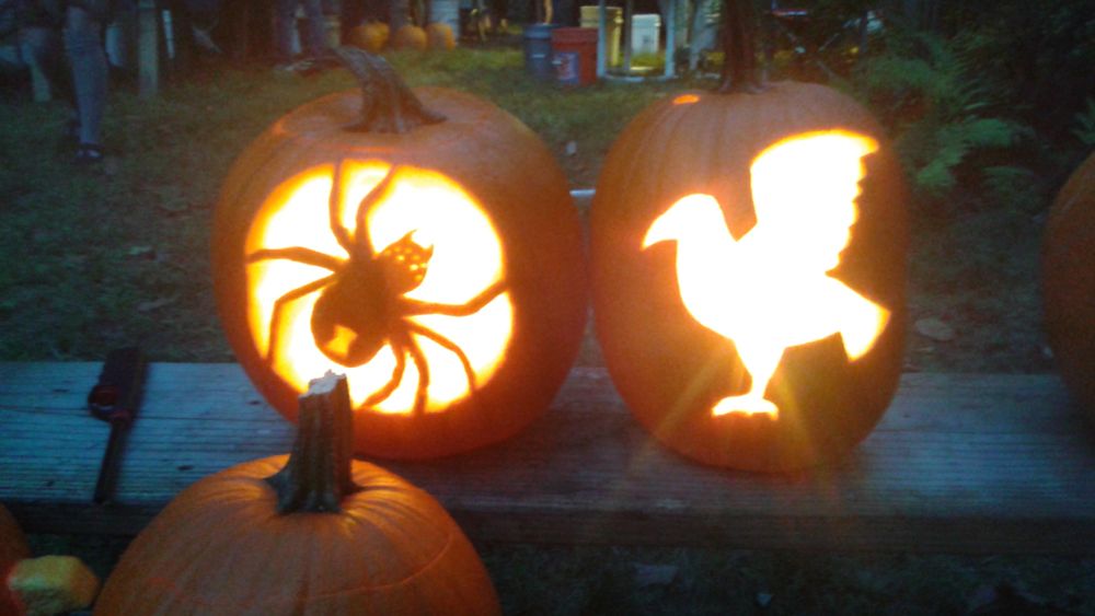 a jack-o-lantern which is carved to resemble a spider. The hourglass on the abdomen and the eyes glow