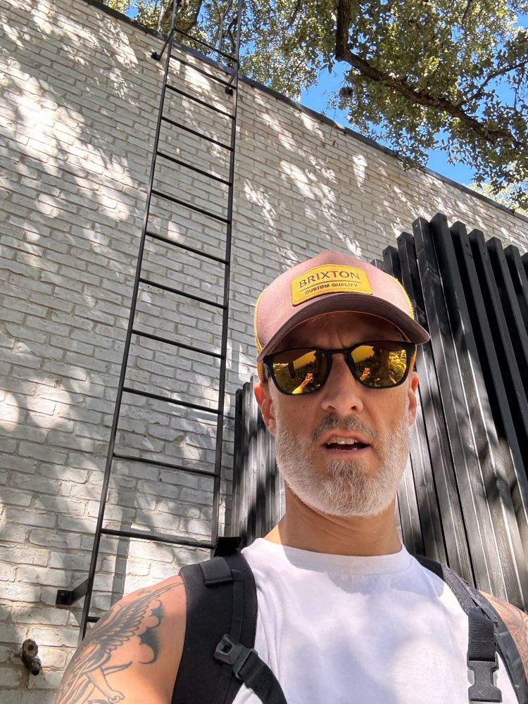 Person in front of a ladder wearing a backpack