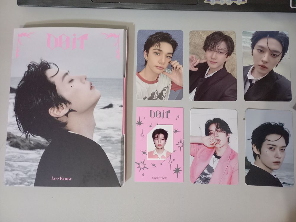 Foto de um álbum do grupo Stray Kids do membro Lee Know, acompanhado de alguns photocards variados.