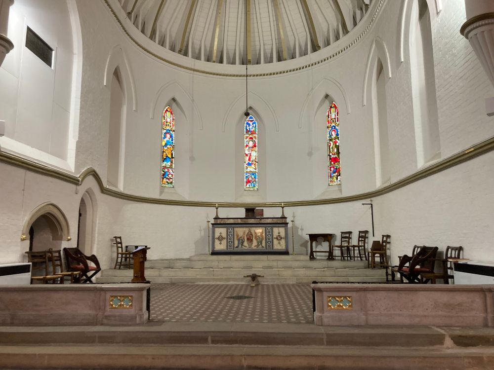 Sanctuary without any decorations: uncovered high altar with open and empty tabernacle on top. The crucifix laying in front on the bare floor
