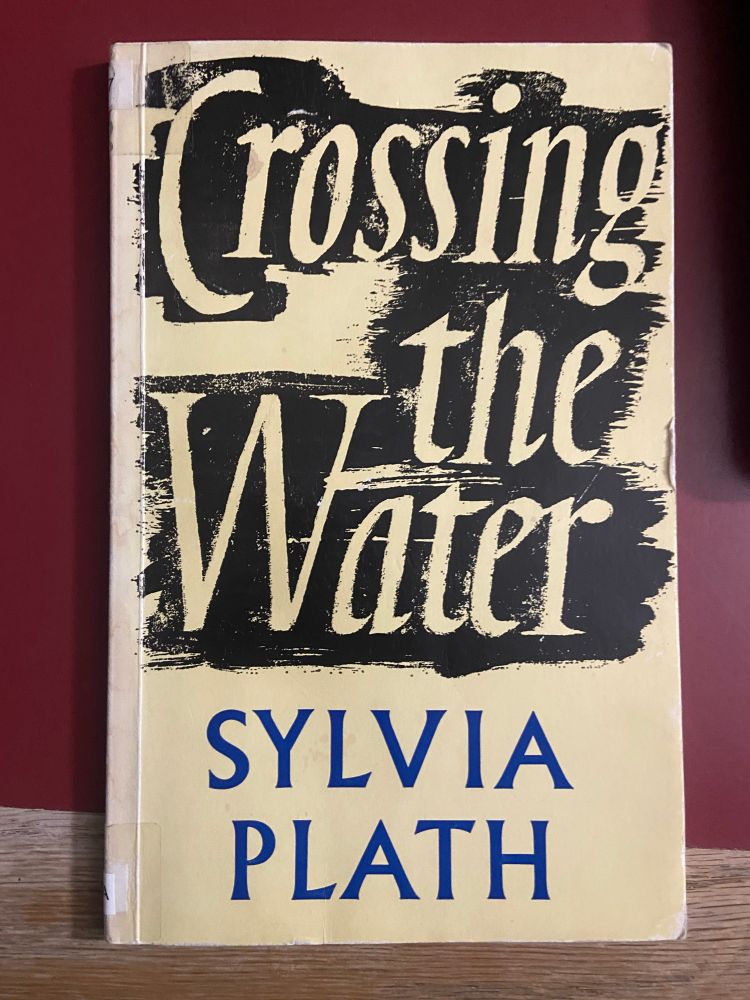 Crossing the Water by Sylvia Plath (paperback), on a red table top