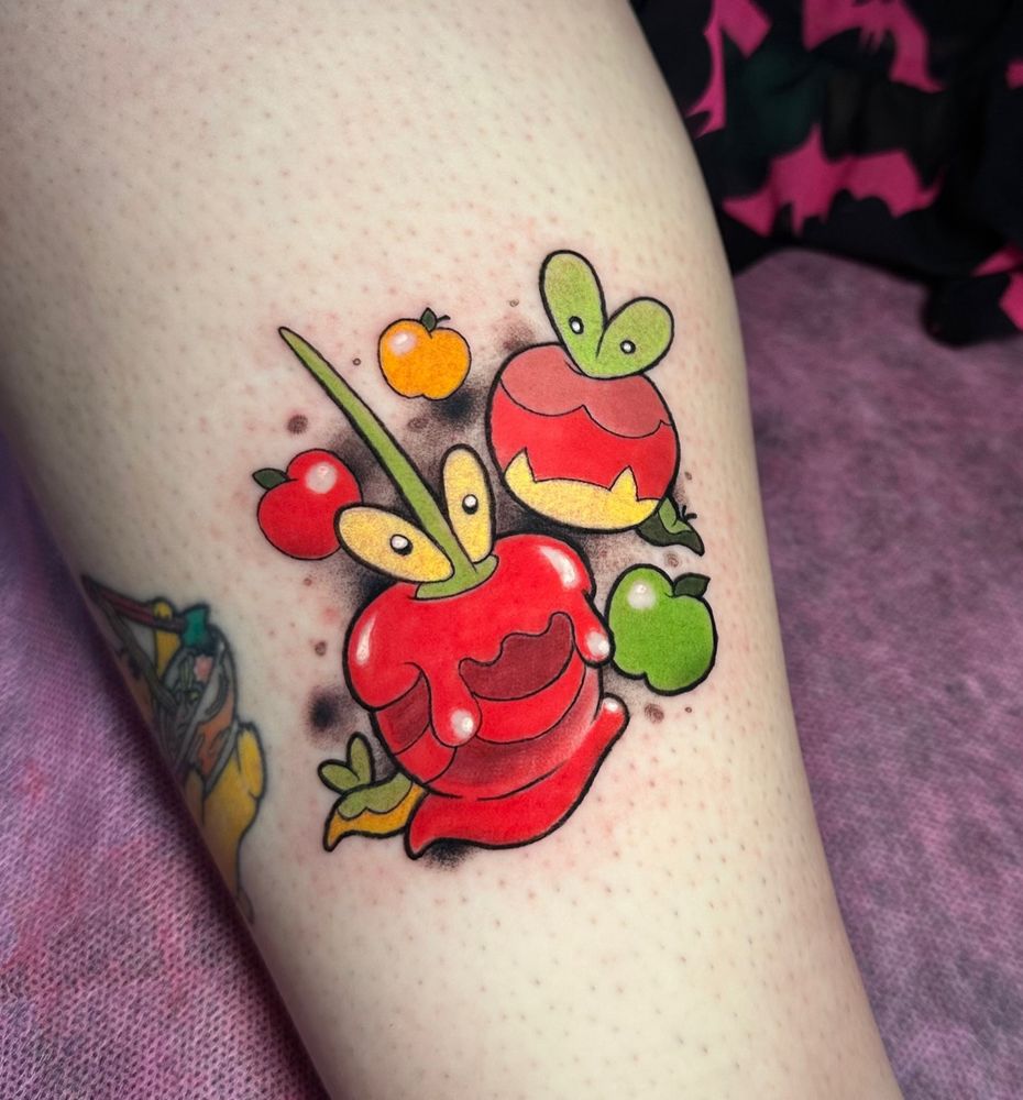 A tattoo on a person's leg of the Pokemon Applin & Dipplin in full color with little apples around them