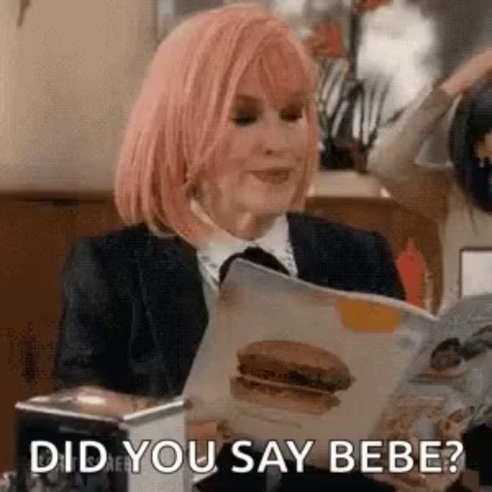 a woman with pink hair is reading a magazine with a picture of a hamburger in it .