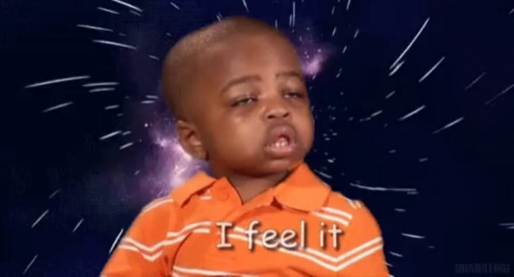 a little boy in an orange shirt is crying and saying `` i feel it '' in front of a space background .