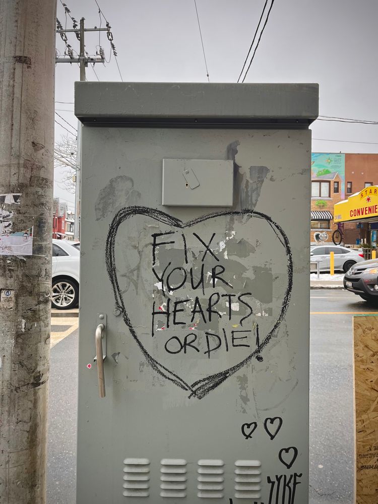 fresh graffiti that reads “fix your hearts or die” 
