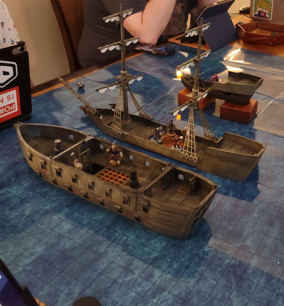 A picture of a model ship with various D&D miniatures on it.