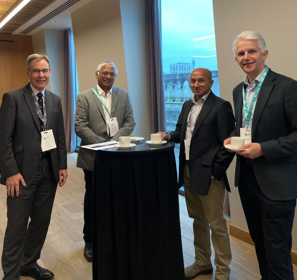 Tim Mitchell, RCS England President, smiles for a photo with two attendees at the Global Surgical Frontiers conference