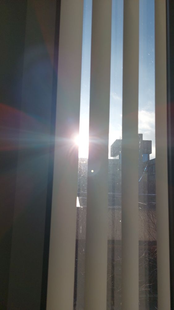 A glimpse of sunshine through office window blinds 
