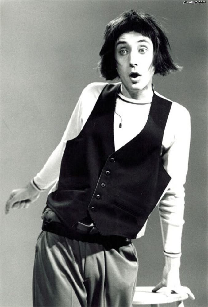 Portrait of comedian Emo Philips in an oversized vest looking doe-eyed. 